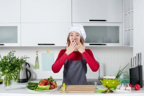 Frustrated woman in kitchen overwhelmed while cooking